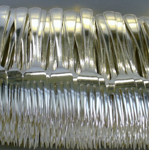 Flatware after application of stainless steel shot in burnishing machine
